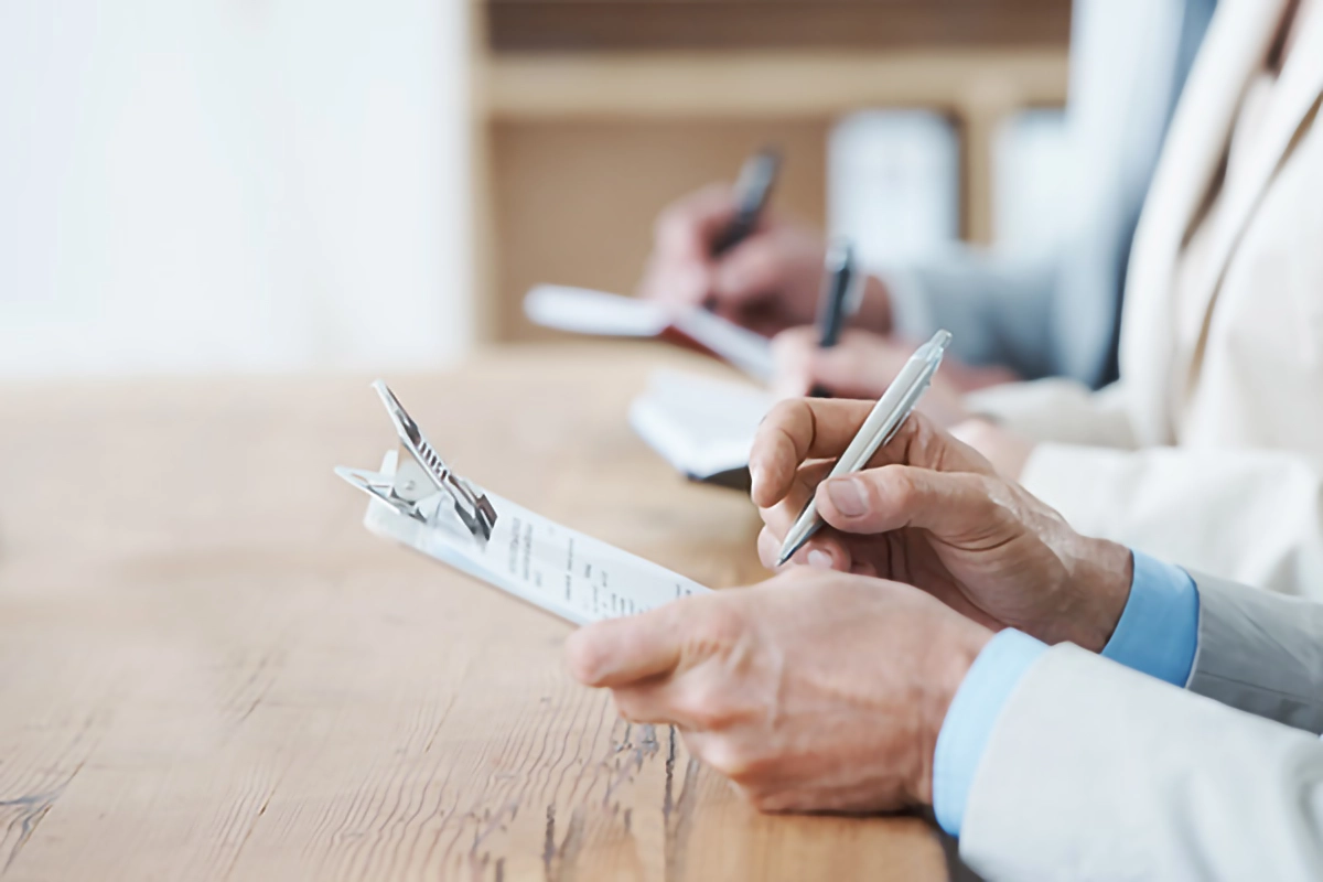 Image of people completing a survey on a conference table